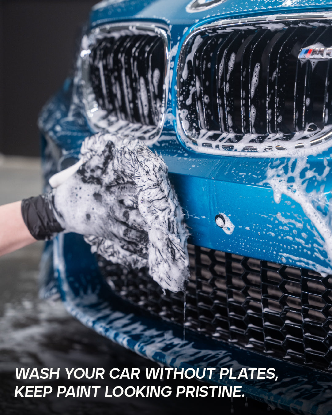 Washing a blue BMW M bumper with the license plate removed using QuickPlate magnetic holder